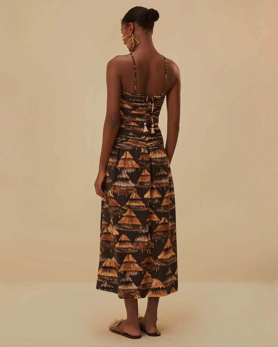 back view of model wearing brown maxi dress with cutout front, tie halter neckline and burnt orange fan print