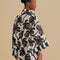 back view of model wearing black and white palm tree kimono top and matching shorts
