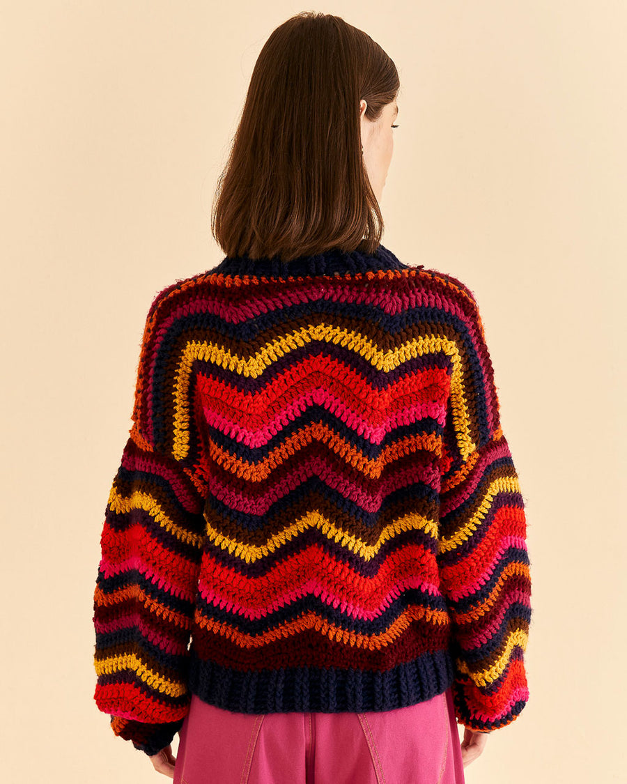 backview of model wearing colorful wavy stripe sweater with high neckline