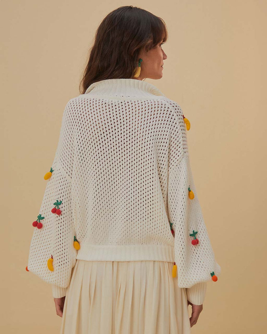 back view of model wearing white open stitch top with 3D fruit,  collar, and v-neckline
