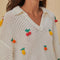 up close of model wearing white open stitch top with 3D fruit,  collar, and v-neckline