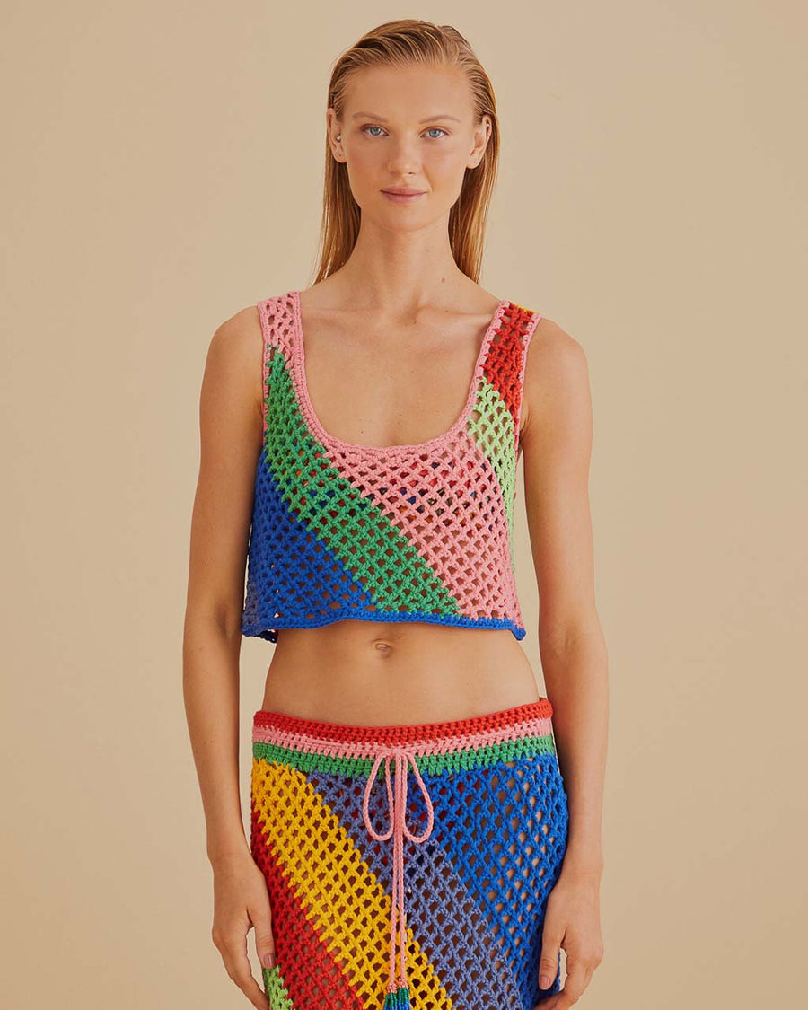model wearing open crochet cropped tank with diagonal rainbow stripes and matching skirt