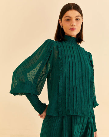 model wearing emerald green blouse with smocked mock neckline, puff sleeves with smocked wrists and pleated front