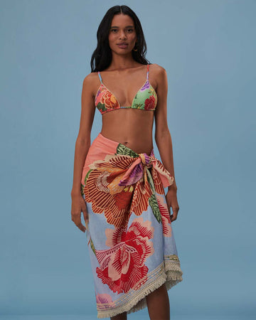 model wearing blue sarong with abstract floral print with tan fringe on the end
