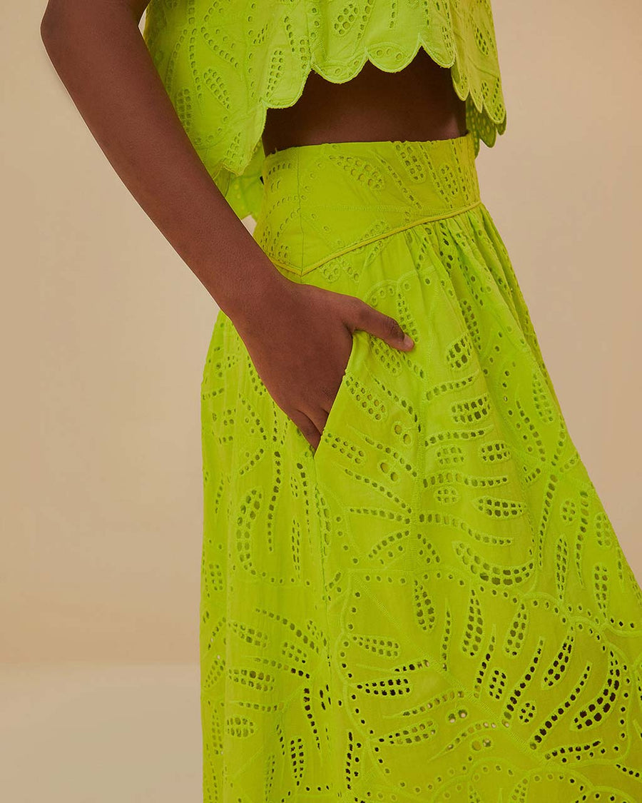 side view of model wearing lime green eyelet maxi skirt with pockets