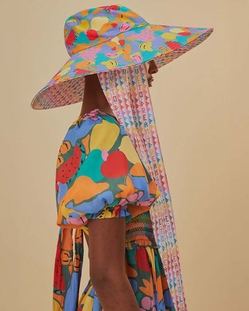 model wearing colorful fruit floppy beach hat with typography inside and long tie straps