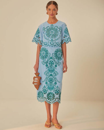 model wearing light blue midi skirt with delicate green cut out pattern and matching top