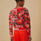 back view of model wearing two tone cropped cardigan with red papaya and pink papaya