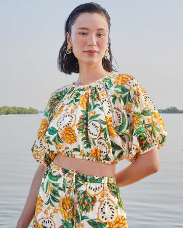 model wearing white cropped blouse with mixed fruit print  and slight puff sleeves