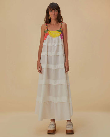model wearing white tiered maxi dress with embroidered fruit top and colorful bulb straps