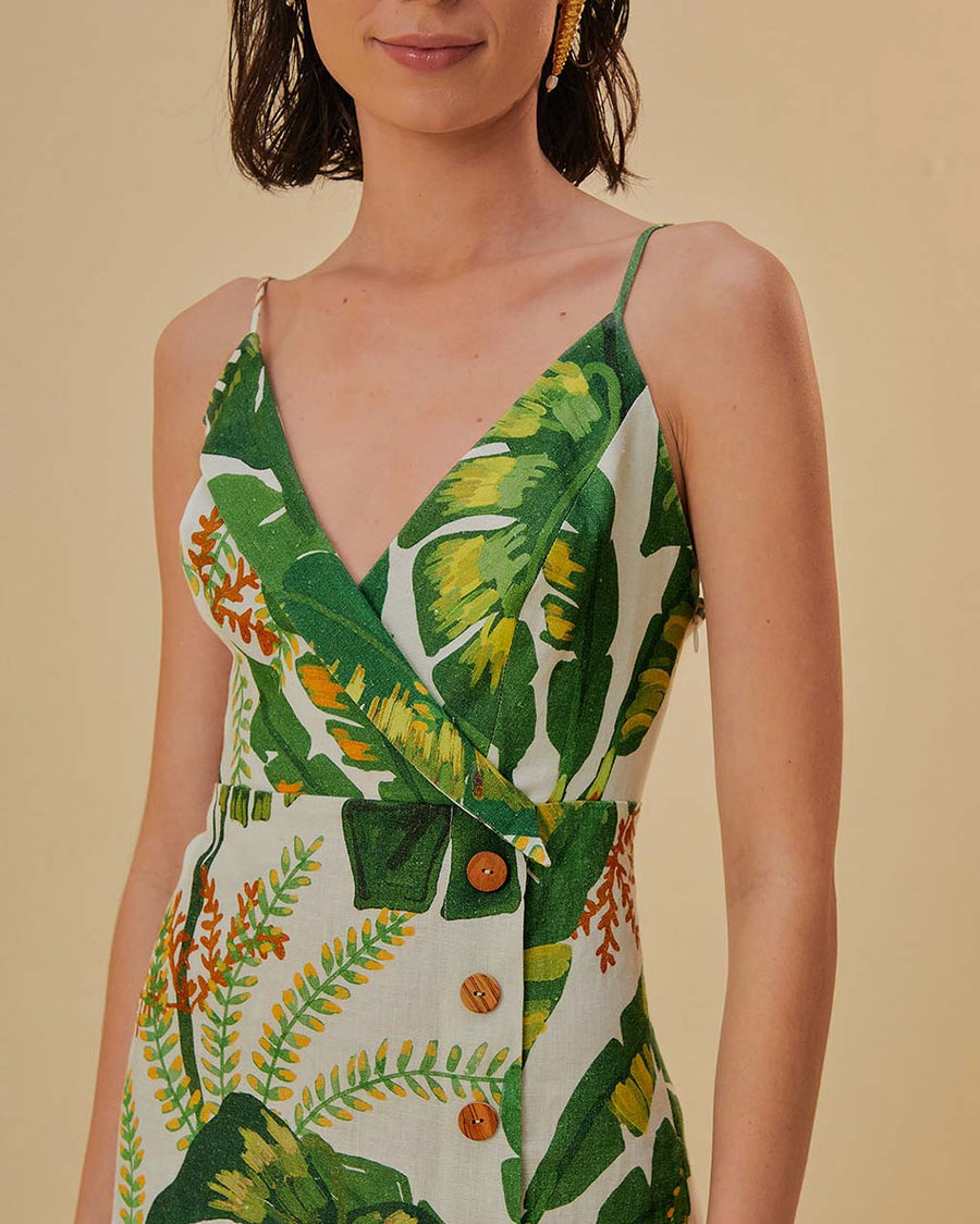up close of model wearing white mini dress with side button detail, v-neckline and green tropical leaf print