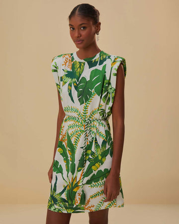 model wearing white t-shirt dress with rope belt, muscle tank sleeves, and green tropical print