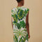 back view of model wearing white t-shirt dress with rope belt, muscle tank sleeves, and green tropical print