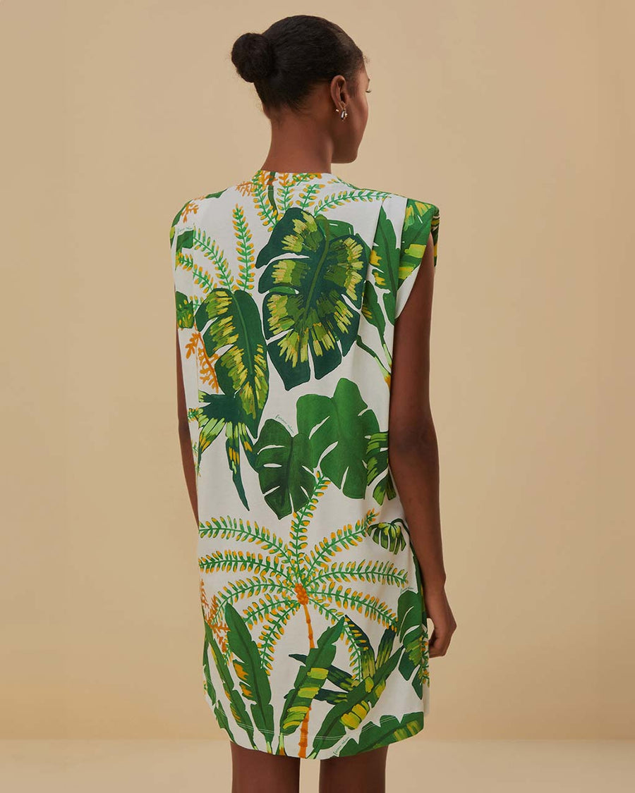 back view of model wearing white t-shirt dress with rope belt, muscle tank sleeves, and green tropical print
