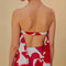 back view of model wearing white cropped tube top with pink and red painted heart pattern