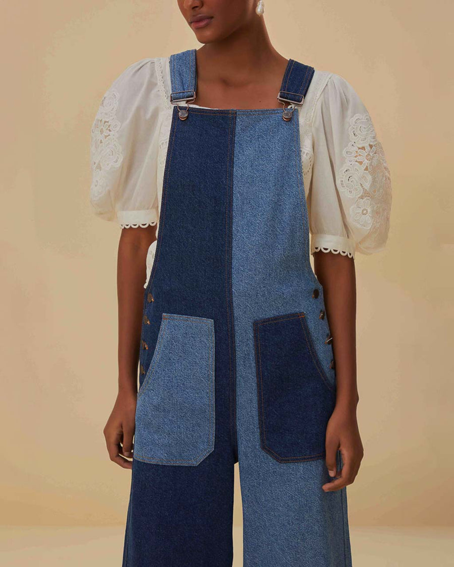 up close of model wearing light blue and dark blue overalls with patch front pockets