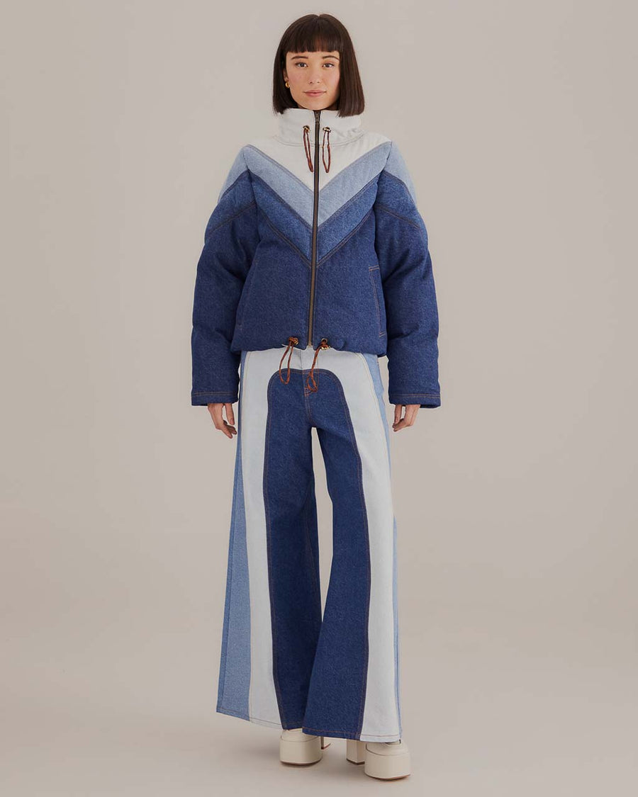  model wearing patchwork wide leg denim in three tones of blues with matching coat