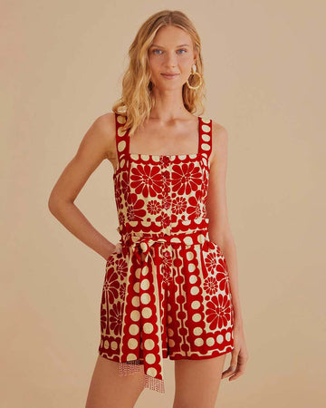 model wearing cream and red abstract romper with tie waist and button front