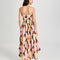 back view of model wearing pink midi dress with curved hem, corset bodice, and colorful abstract print