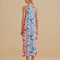 back view of model wearing colorful floral patchwork midi dress with pom seam detail and pockets
