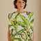 model wearing off white square shoulder top with green tropical leaf print