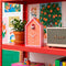 pink and orange vertical stripe house shaped alarm clock with white cuckoo on an red shelf