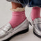 model wearing bubblegum pink waffle socks with cream crochet ruffle trim and silver loafers