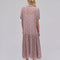 back view of model wearing pink floral drop waist midi dress with periwinkle trim on the neckline and puff sleeves