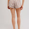back view of model wearing cream and brown plaid crinkle boxer shorts