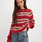 model wearing red sweater with white and orange stripes