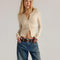 model wearing cream woven cardigan with criss-cross details and ruffles on the hem and sleeves