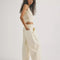 side view of model wearing cream relaxed fit jeans with elastic waist and drawstring