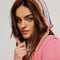 model wearing light blue, peach, brown and white stripe bonnet hat with tie straps