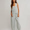 model wearing relaxed fit blue and white railroad stripe overalls with a white tank