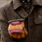 model carrying orange, pink, green and brown striped gloves/mittens in their pocket