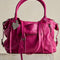 raspberry pink leather tote bag with several zipper pockets, double handles, and crossbody strap