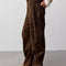 side view of model wearing dark brown vegan suede pants and oatmeal sweater