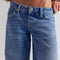 up close of model wearing low rise medium denim wash boyfriend jeans
