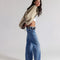 side view of model wearing low rise medium denim wash boyfriend jeans