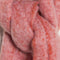 up close of thick pink and white oversized scarf with red fringe