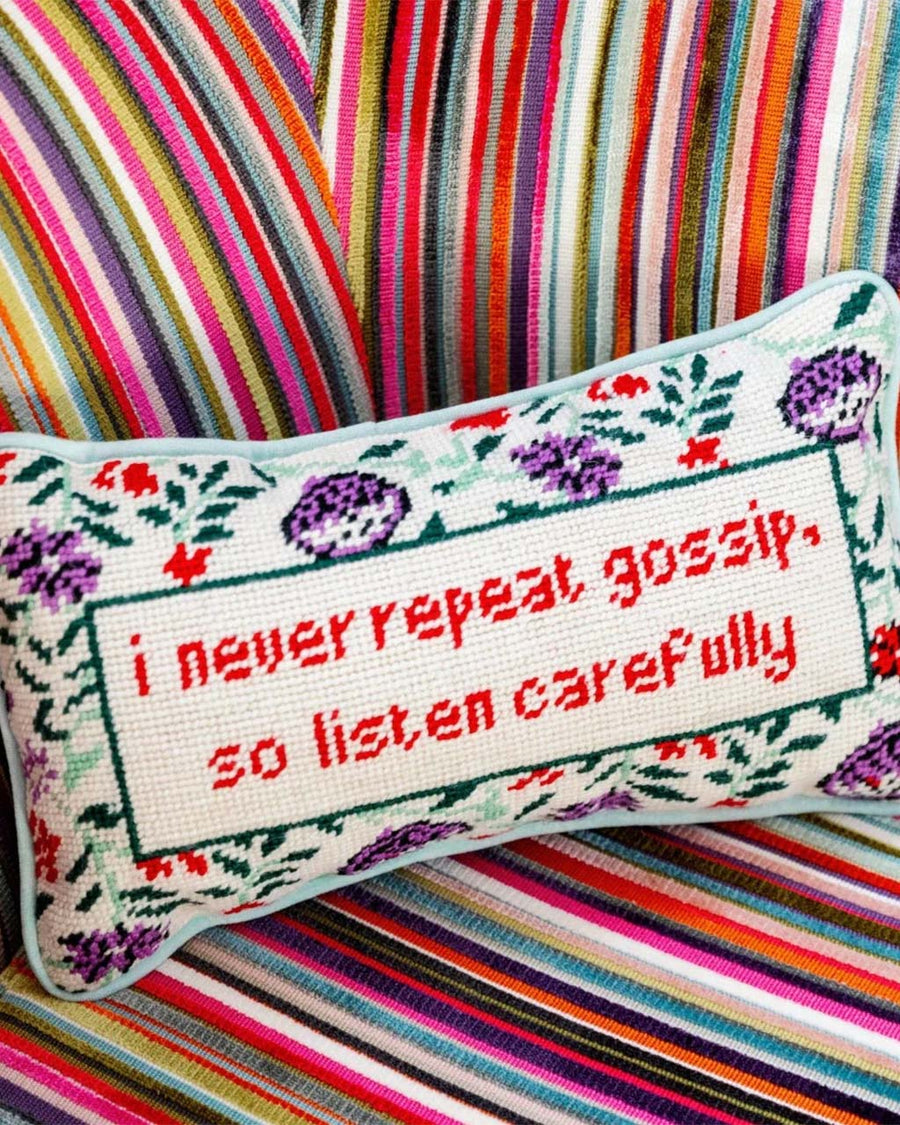 floral rectangular throw pillow with 'i never repeat gossip, so listen carefully' across the front on couch