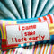 colorful striped rectangular throw pillow with 'i came, i saw, i left early' across the front on couch