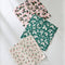 set of three holiday dish cloths: pink with holly print, green with shadow holly print, and white with dainty sprig print