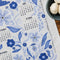 up close of white tea towel with blue sparrow birds and 2026 'calendar' by month