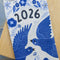 front view of white tea towel with blue sparrow birds and 2026 'calendar' by month