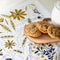 white tea towel with goldenrod floral and bee print with cookies on them