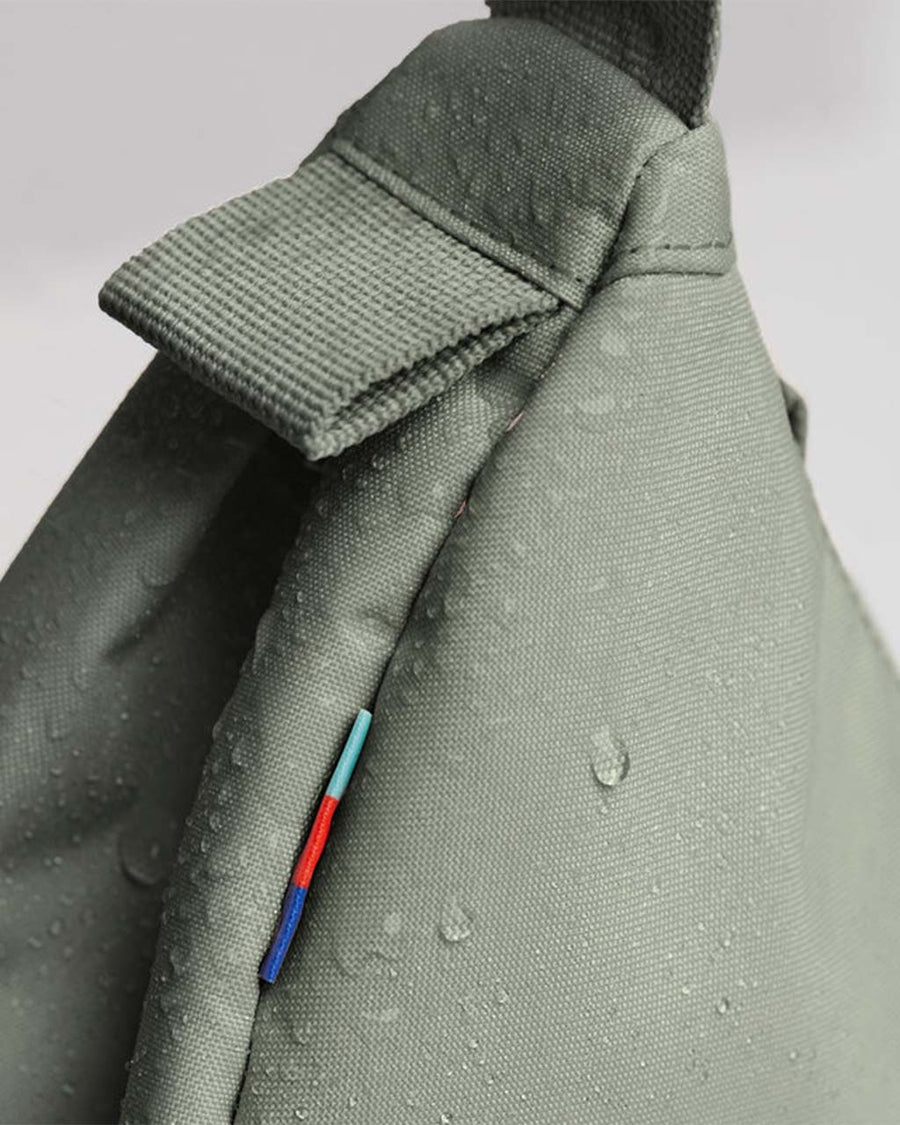 up close of water resistant fabric on sage green small got bag with subtle sheen