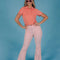 model wearing powder pink corduroy bell bottoms with melon colored polo