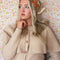 model wearing cream background bandana with orange, green, gold and pink with chocolate brown outlines