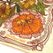 up close of cream background bandana with orange, green, gold and pink with chocolate brown outlines